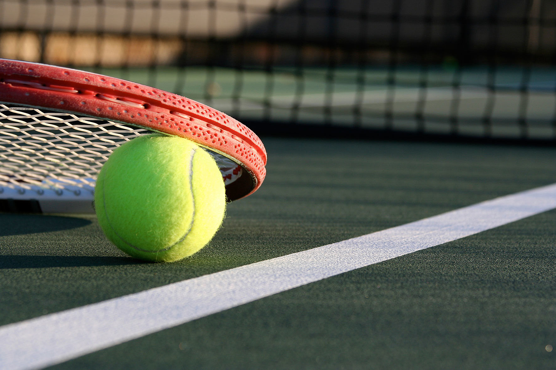 Nahaufnahme - Tennisball mit Tennisschläger auf Tennisplatz