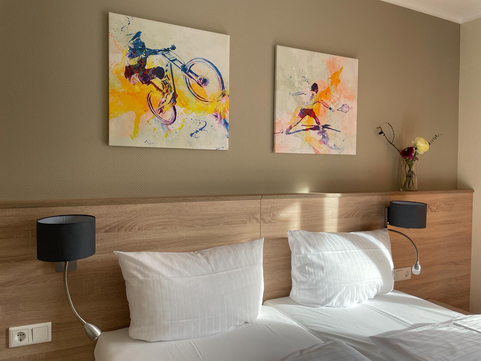 Helles und freundliches Ambiente im Comfort Zimmer: Gemütliches Bett mit Kunst an der Wand und sonnendurchflutetem Raum.