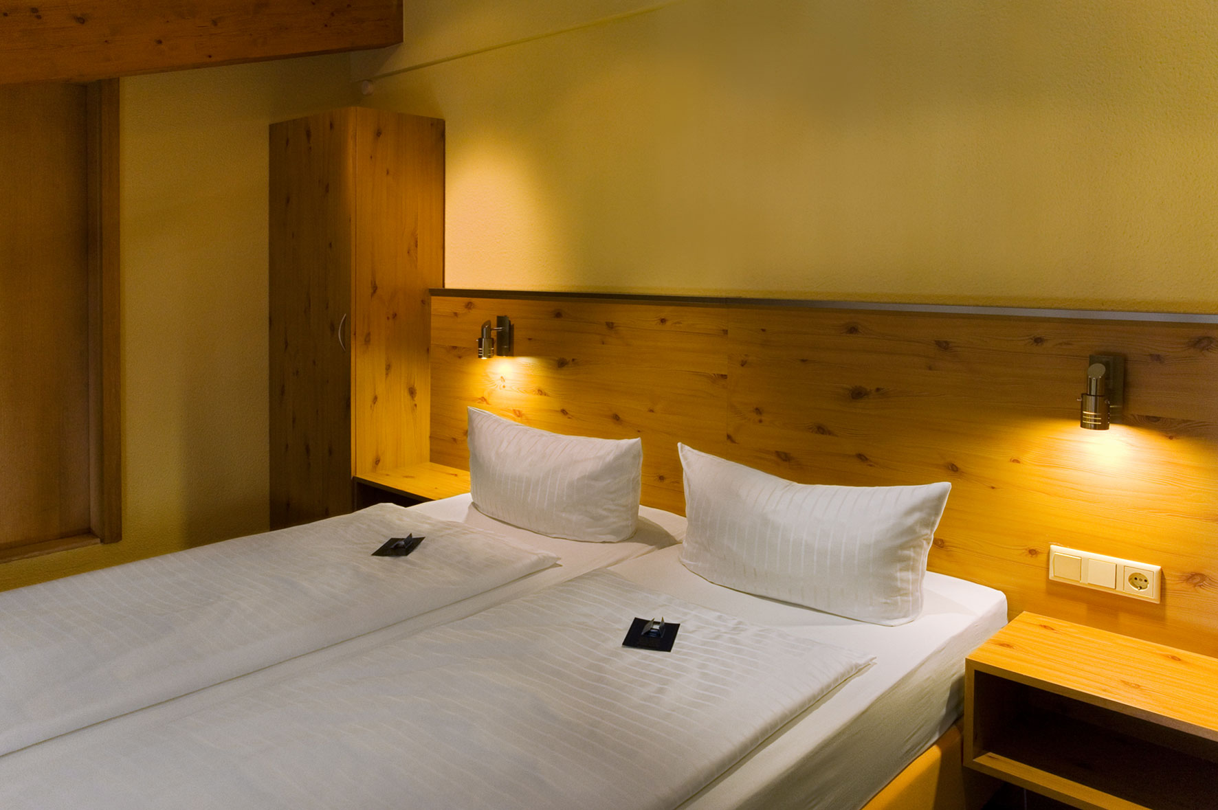 Gemütliches Hotelzimmer mit Holzverkleidung und warmem Licht im aktiv Sporthotel Pirna.